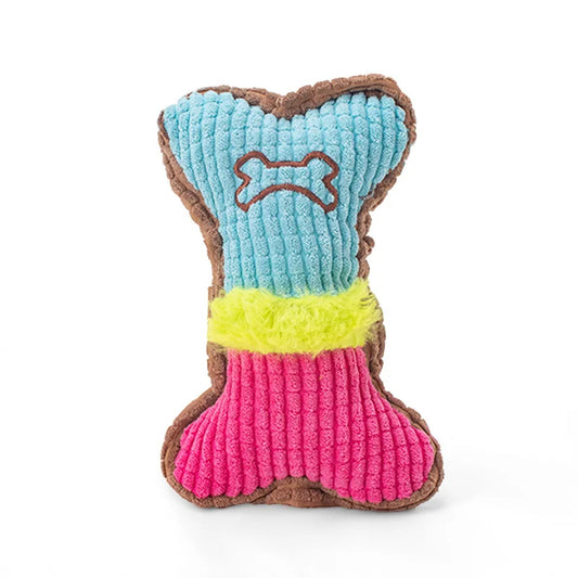 Colorful plush dog toy shaped like a bone, featuring textured blue, pink, and yellow sections with embroidered bone design and soft brown trim